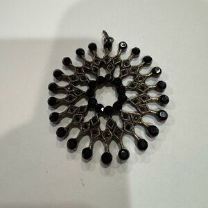 Circular black and melanite-tone crystal starburst-shaped pendant 2 1/4” D